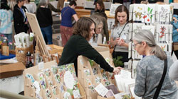 Maia Hausler sells items at the art market.