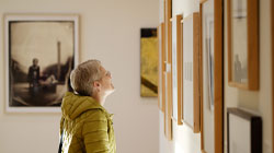 a woman looking at artwork