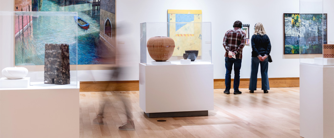 Visitors walking through the exhibit "New Perspectives: Selections from the Dennos Museum Permanent Collection" in 2026. 
